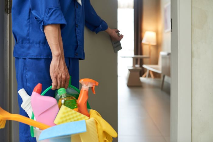 nosotros/unrecognizable-cleaner-walking-into-hotel-room-with-tools-detergents.jpg